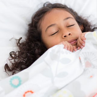 Child sleeping with covers up around her face as if scared.