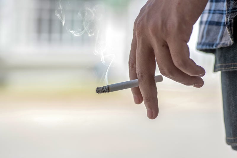 Man's hand holding cigarette